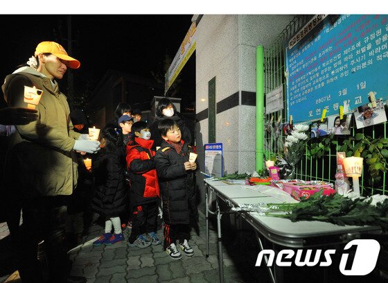 본문 이미지 - 울산에서 계모의 학대로 숨진 A양의 넋을 기리기 위한 촛불추모제가 13일 저녁 A양이 다니던 학교 앞에서 열리고 있다. 숨진 아이의 또래로 보이는 초등학생들이 촛불을 들고 있다. 2013.11.13/뉴스1 © News1   노화정  기자