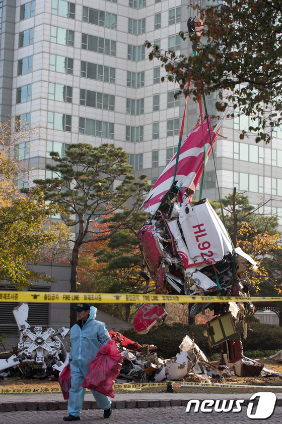 (서울=뉴스1) 유승관 기자 = 16일 오전 서울 삼성동 아이파크 아파트에 민간 헬리콥터가 충돌해 추락하는 사고가 발생했다.이날 오후 인부들이 추락한 헬기 잔해를 인양하고 있다.이 …