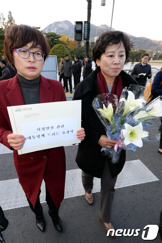 (서울=뉴스1) 정회성 기자 = 민주당 은수미(왼쪽), 남윤인순 의원이 17일 오후 '시정연설 관련 대통령께 드리는 요청서'와 진실을 상징하는 백합꽃을 청와대에 전달하기 위해 서울 …