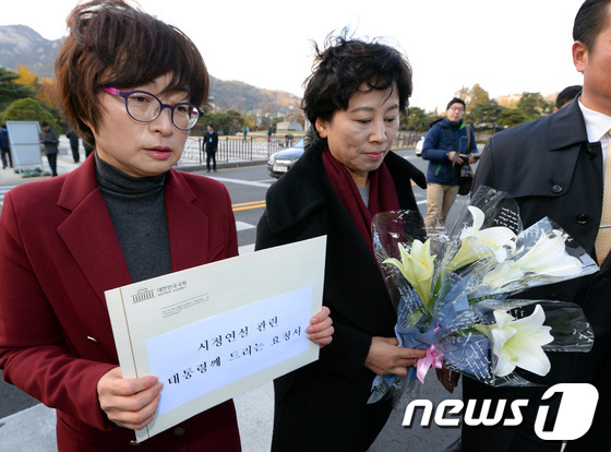 (서울=뉴스1) 정회성 기자 = 민주당 은수미(왼쪽), 남윤인순 의원이 17일 오후 '시정연설 관련 대통령께 드리는 요청서'와 진실을 상징하는 백합꽃을 청와대에 전달하기 위해 서울 …