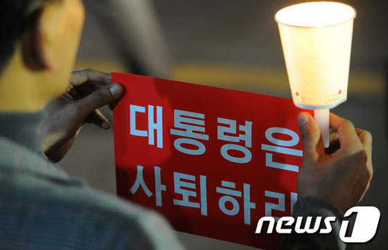 (군산=뉴스1) 김대웅 기자 = 국가기관의 불법 대선 부정선거 규탄과 박근혜 대통령 사퇴를 촉구하는 시국미사가 열린 22일 오후 전북 군산시 수송동성당 앞에서 신자들이 촛불집회를 …