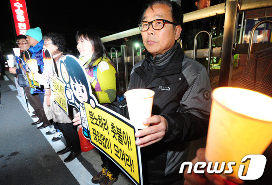 (군산=뉴스1) 김대웅 기자 = 국가기관의 불법 대선 부정선거 규탄과 박근혜 대통령 사퇴를 촉구하는 시국미사가 열린 22일 오후 전북 군산시 수송동성당 앞에서 신자들이 촛불집회를 …