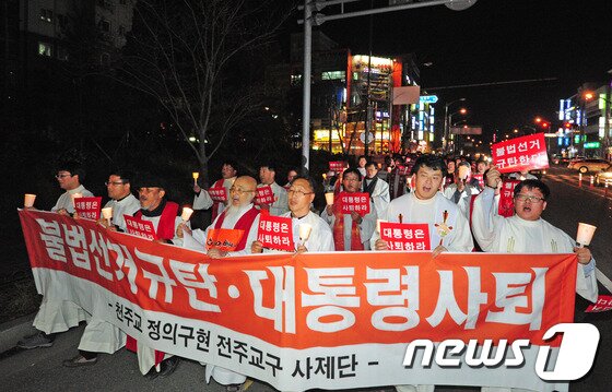 본문 이미지 - 22일 밤 천주교정의구현사제단 전주교구 신부들과 신자들이 전북 군산시 수송동 롯데마트 앞에서 '대통령 사퇴' 구호를 외치며 행진하고 있다.각 2013.11.22/뉴스1 © News1 김대웅 기자