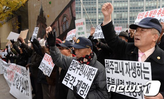 본문 이미지 - 어버이연합 회원들을 비롯한 보수단체 회원들이 24일 오후 서울 중구 명동성당에서 천주교 정의구현사제단을 규탄하는 기자회견을 열어 구호를 외치고 있다. 이들은 천주교 정의구현사제단 전주교구 박창신 신부가 박근혜 대통령 사퇴와 연평도 포격 도발을 정당화하는 발언을 한 것에 대해 