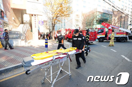 본문 이미지 - 119대원들이 불이 난 포항시 남구 대잠동 대잠그린파크 명품 아파트 상가로 구급장비를 옮기고 있다./최창호 기자© News1 