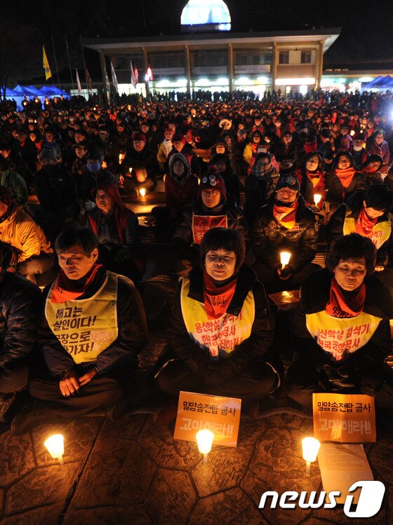 본문 이미지 - 30일 오후 경남 밀양역 광장에서 열린 말양 송전탑 희망버스 문화제에서 송전탑 공사 반대 주민들과 희망버스 참가자들이 촛불을 켜고 공연을 관람하고 있다. 2013.11.30/뉴스1 © News1 전혜원 기자