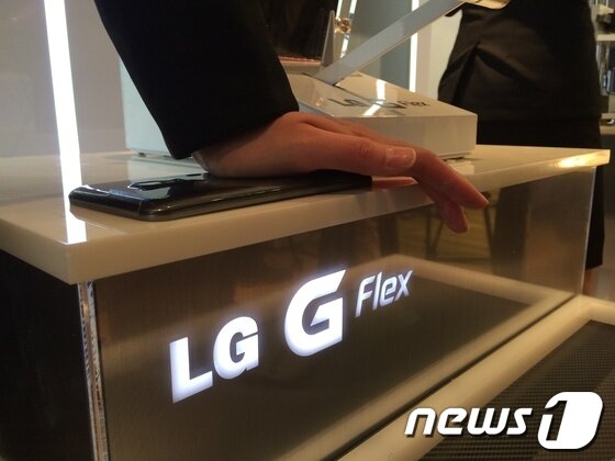 본문 이미지 - 휘어지는 디스플레이와 배터리를 장착한 LG전자의 &#39;G플렉스&#39; 스마트폰은 덕분에 강한 힘을 가해도 스마트폰이 펴졌다가 다시 구부러진 상태로 돌아온다.© News1 