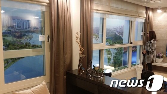 본문 이미지 - 전용58㎡(B1타입) 유니트서 한 고객이 광교호수공원 조망권에 대한 설명을 듣고있다/사진=임해중 기자© News1 