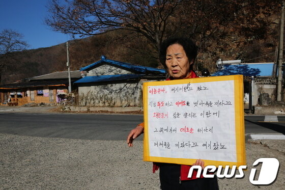 본문 이미지 - 단장면 바드리마을에서 한 할머니가 30일 오후 희망버스 도착시점에 맞춰 1인 시위를 하고 있는 모습. © News1 