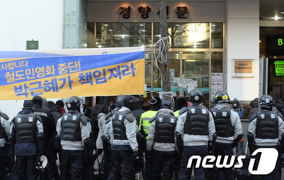 본문 이미지 - 민주노총 총파업 결의대회가 열리고 있는 2013년 12월28일 오후 경찰들이 김명환 철도노조 위원장이 있는 서울 정동 민주노총 앞을 지키고 있다. 경찰 체포 우려한 김명환 철도노조 위원장은 민노총 사무실에서 영상 연설을 한다. .2013.12.28/뉴스1