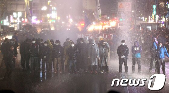 본문 이미지 - 한국진보연대, 민주노총을 비롯한 100여개 노동조합과 시민사회단체 참가자들이 7일 오후 서울역광장에서 '박근혜 정부 규탄 비상시국대회'를 마치고 도심으로 행진을 벌이다 종로3가에서 인도로 물러날 것을 요구하는 경찰이 쏜 물대포를 맞고 있다. 2013.12.7/뉴스1 © News1 한재호 기자
