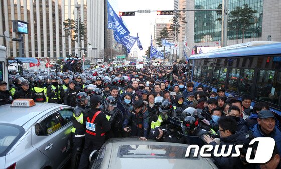 본문 이미지 - 한국진보연대, 민주노총을 비롯한 100여개 노동조합과 시민사회단체 참가자들이 7일 오후 서울역광장에서 '박근혜 정부 규탄 비상시국대회'를 마치고 도심으로 행진을 벌이다 신고된 구간을 이탈했다며 막아선 경찰과 길을 지나던 시민, 차량들과 뒤엉키고 있다. 2013.12.7/뉴스1 © News1   한재호 기자
