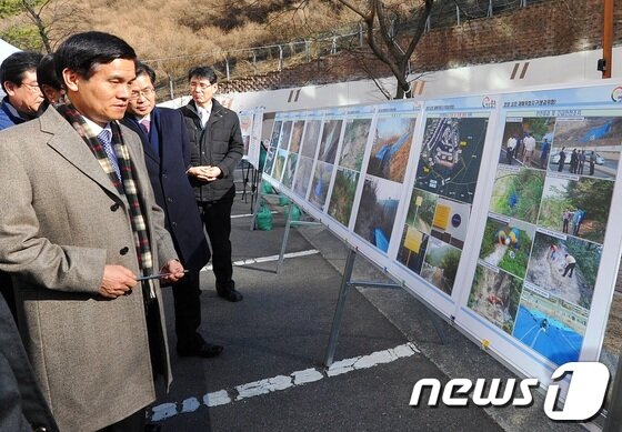 본문 이미지 - 2월 20일 오후 울산시 울주군 청량면에 소재한 아파트 재해방지 대책마련 요구 민원 현장을 찾은 이성보 국민권익위원장이 현황판을 살펴보고 있다. 2013.2.20/뉴스1 © News1   노화정 기자