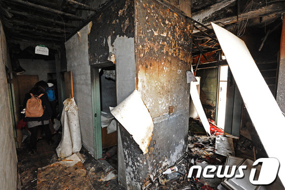 (전주=뉴스1) 김대웅 기자 = 전북 군산 개복동 성매매 업소 화재 참사 현장 철거를 하루 앞둔 25일 여성 단체회원들이 11년동안 막아두었던 화재 현장을 둘러 보고 있다.군산 개 …