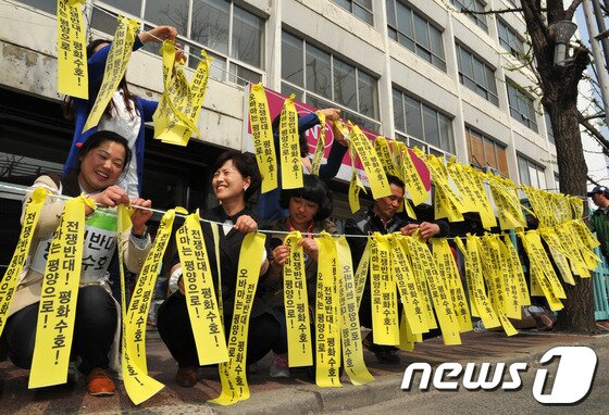 본문 이미지 - 6.15 공동선언실천 남측위원회 광주전남본부 등 광주지역 시민단체회원 20여명이 15일 오후 광주 동구 금남로 전일빌딩 앞에서 한반도 평화 실현을 기원하며 '평화리본달기' 캠페인을 벌이고 있다. 2013.4.15/뉴스1 © News1 정회성 