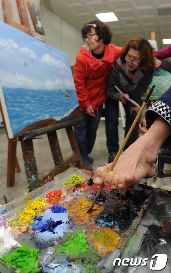 (서울=뉴스1) 박지혜 기자 = 제33회 장애인의 날을 하루 앞둔 17일 오전 서울 송파구 삼전동 구민회관에서 열린 장애인 그림동호회 '화사랑'의 전시회에서 구족화가가 바다를 주제 …