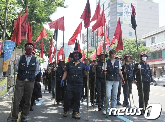 본문 이미지 - 지난 13일 2차 총파업에 들어간 울산건설기계노조 조합원들이 붉은 깃발을 앞세우고 가두행진을 벌이고 있다. 이들은 적정임대료 보장, 일요휴무, 장시간 노동문제 개선 등을 요구하고 있다. 2013.5.13/뉴스1  © News1   노화정 기자 