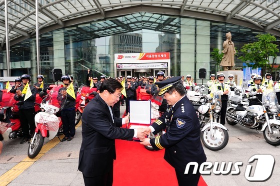 (서울=뉴스1) 한재호 기자 = 14일 오전 서울 중구 포스트타워 앞 광장에서 열린 '국민행복 살피미' 출범식에 참석한 이승재 서울지방우정청장과 김정석 서울지방경찰청장이 악수를 하 …