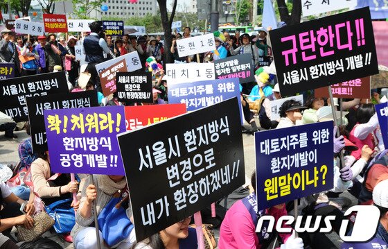 본문 이미지 - 15일 오후 서울 코엑스 앞에서 강남구 주민자치위원회 회원들이 서울시의 구룡마을 일부환지 개발방식 변경에 반대하는 집회를 열고 구호를 외치고 있다. 이들은 
