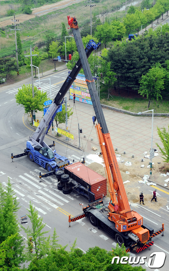 (시흥=뉴스1) 양동욱 기자 = 18일 경기도 시흥시 정왕동 무진아파트 앞 도로에서 화물차에 실려있던 컨테이너가 넘어지면서 불산 40여ℓ가 유출되는 사고가 발생해 출동한 소방대원들 …