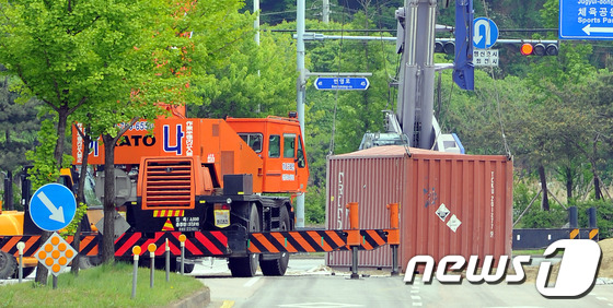 (시흥=뉴스1) 양동욱 기자 = 18일 경기도 시흥시 정왕동 무진아파트 앞 도로에서 화물차에 실려있던 컨테이너가 넘어지면서 불산 40여ℓ가 유출되는 사고가 발생해 출동한 소방대원들 …