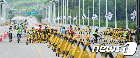 (파주=뉴스1) 박철중 기자 = DMZ 자전거 투어에 나선 시민들이 19일 오후 경기도 파주 통일대교 남측 출입문을 향해 내려오고 있다. 이날 통일부는 대변인을 통해 북한의 유도탄 …