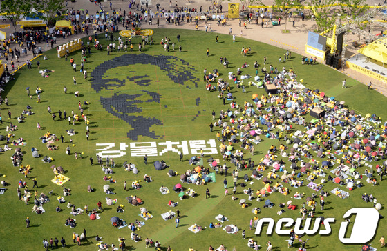 (서울=뉴스1) 박세연 기자 = 노무현 4주기 추모문화제가 열린 19일 오후 시민들이 종이를 이어붙여 서울광장에 노무현 전 대통령의 얼굴을 만들고 있다.2013.5.19/뉴스1