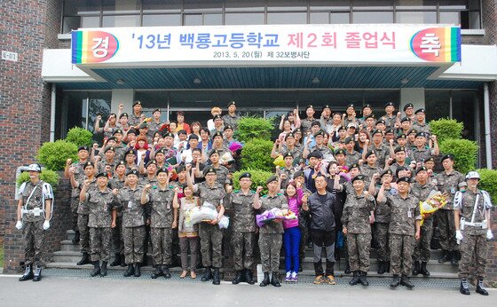 본문 이미지 - 20일 육군 제32보병사단에서 고교 검정고시를 합격한 부대원을 대상으로 제2회 백룡고 졸업식이 열렸다. 졸업생과 졸업생 가족들이 단체사진을 찍고 있다. © News1  