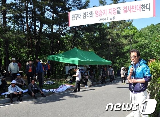 본문 이미지 - 21일 문화재청의 문화재위원들에 대한 암각화 현장설명회에서 인근 주민들이 암각화 현장으로 통하는 길을 가로 막고 명승지정 반대를 외치며 시위를 벌이고 있다.© News1 노화정 기자 