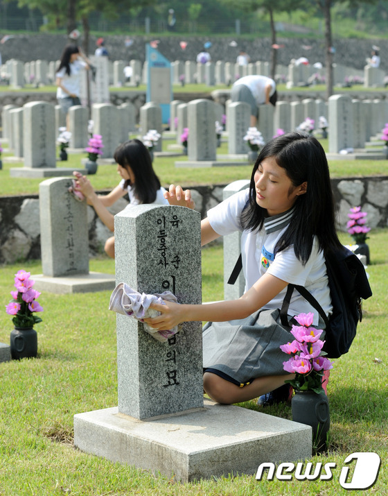 (서울=뉴스1) 박세연 기자 = 23일 오전 서울 동작구 국립서울현충원에서 열린 '한사람 한송이 헌화운동'행사를 찾은 거원중학교 학생들이 묘역 정화 활동을 하고 있다. 한사람 한송 …