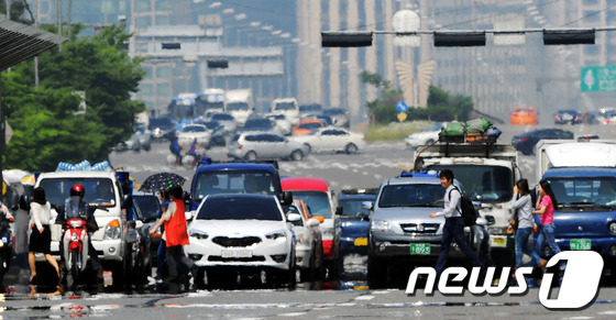 (서울=뉴스1) 양동욱 기자 = 서울의 낮 최고기온이 30도까지 오르며 올들어 가장 더운 날씨를 보인 23일 서울 여의대로 횡단보도에서 아스팔트의 아지랑이 사이로 시민들이 발걸음을 …