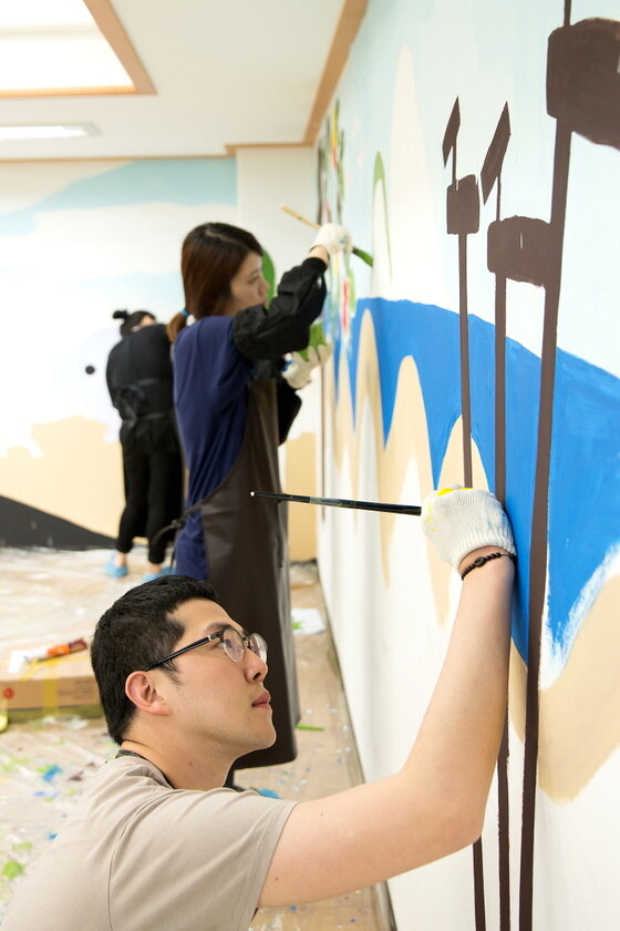 본문 이미지 - CJ E&M 임직원들이 구립 노인복지시설 '한서데이케어센터'에서 벽화 그리기 봉사활동을 진행하고 있다.© News1  