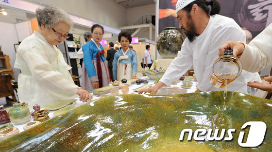 (대구=뉴스1) 김영진 기자 = 23일 대구 북구 엑스코에서 열린 ‘2013 대구세계茶문화축제’에 참가한 시민들이 한 도예가 부부의 작품을 둘러보고 있다. 차문화축제는 23일 개막 …