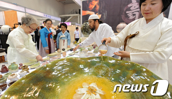 (대구=뉴스1) 김영진 기자 = 23일 대구 북구 엑스코에서 열린 ‘2013 대구세계茶문화축제’에 참가한 시민들이 한 도예가 부부의 작품을 둘러보고 있다. 차문화축제는 23일 개막 …
