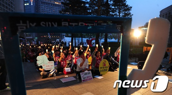 (서울=뉴스1) 한재호 기자 = 23일 오후 서울시청 앞에서 열린 콜센터 감정노동자 노동인권 보장을 위한 촛불문화제에 참가자들이 구호를 외치고 있다. 문화제에는 공공기관의 콜센터에 …