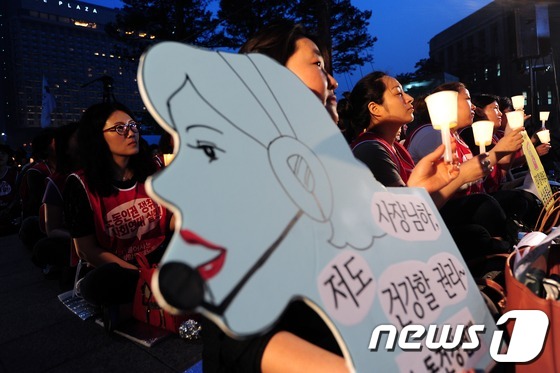 서울시청 앞에서 열린 콜센터 감정노동자 노동인권 보장을 위한 촛불문화제에 참가자들이 촛불을 들고 있다. 2013.5.23/뉴스1