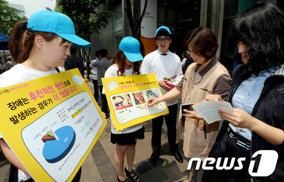 (서울=뉴스1) 양동욱 기자 = 24일 서울 강남구 역삼동 LIG손해보험 빌딩 앞에서 열린 장애인식개선 거리캠페인에서 복지관 자원봉사자들이 시민들을 대상으로 장애인식에 대한 거리캠 …