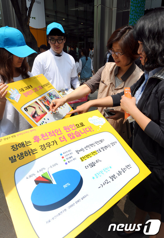 (서울=뉴스1) 양동욱 기자 = 24일 서울 강남구 역삼동 LIG손해보험 빌딩 앞에서 열린 장애인식개선 거리캠페인에서 복지관 자원봉사자들이 시민들을 대상으로 장애인식에 대한 거리캠 …