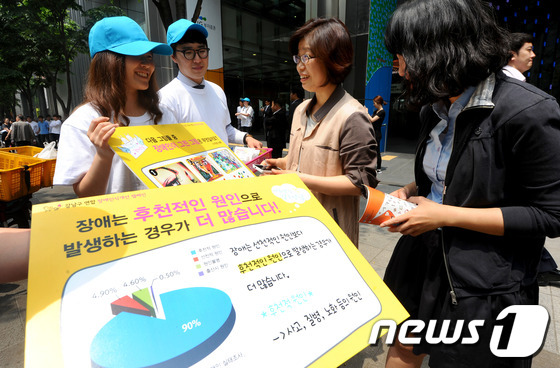 (서울=뉴스1) 양동욱 기자 = 24일 서울 강남구 역삼동 LIG손해보험 빌딩 앞에서 열린 장애인식개선 거리캠페인에서 복지관 자원봉사자들이 시민들을 대상으로 장애인식에 대한 거리캠 …