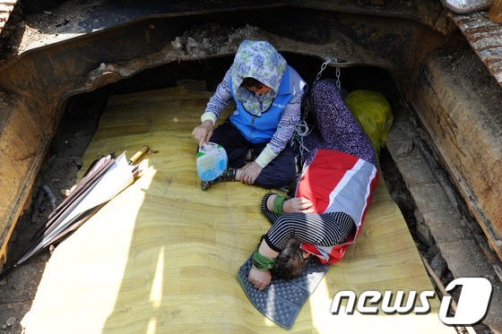 (밀양=뉴스1) 전혜원 기자 = 한전이 밀양지역 765kV 송전탑 공사를 닷새째 이어간 24일 오전 밀양 단장면 바드리 송전탑 공사현장에서 주민들이 굴착기 그늘 아래에서 시위를 벌 …
