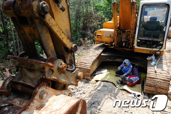 (밀양=뉴스1) 전혜원 기자 = 한전이 밀양지역 765kV 송전탑 공사를 닷새째 이어간 24일 오전 밀양 단장면 바드리 송전탑 공사현장에서 주민들이 굴착기 그늘 아래에서 시위를 벌 …