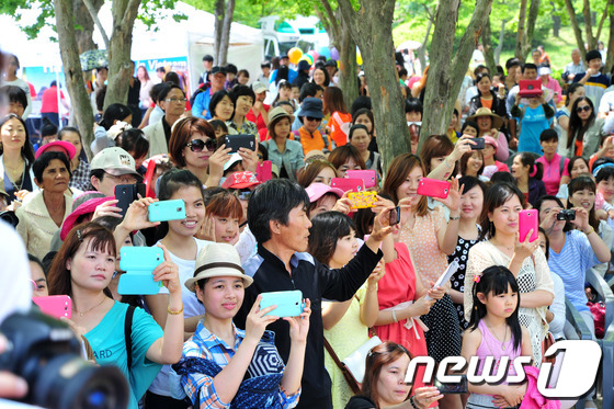 (전주=뉴스1) 김대웅 기자 = 24일 전북 전주 덕진공원에서 전북다문화가족지원센터협회 주관으로 열린 '제6회 전북 다문화 어울림 축제'에 참석한 결혼이주여성들이 공연을 보며 사진 …