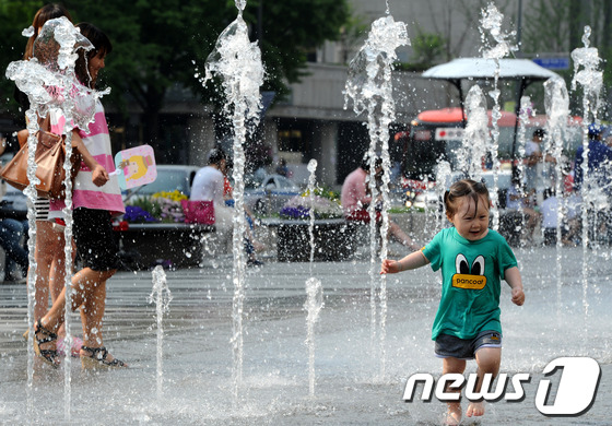 (서울=뉴스1) 안은나 기자 = 서울 낮 기온 28도 등 전국적으로 30도 안팎의 한여름 더위가 이어지고 있는 24일 서울 광화문 광장에서 한 어린이가 장난을 치며 즐거워하고 있다 …