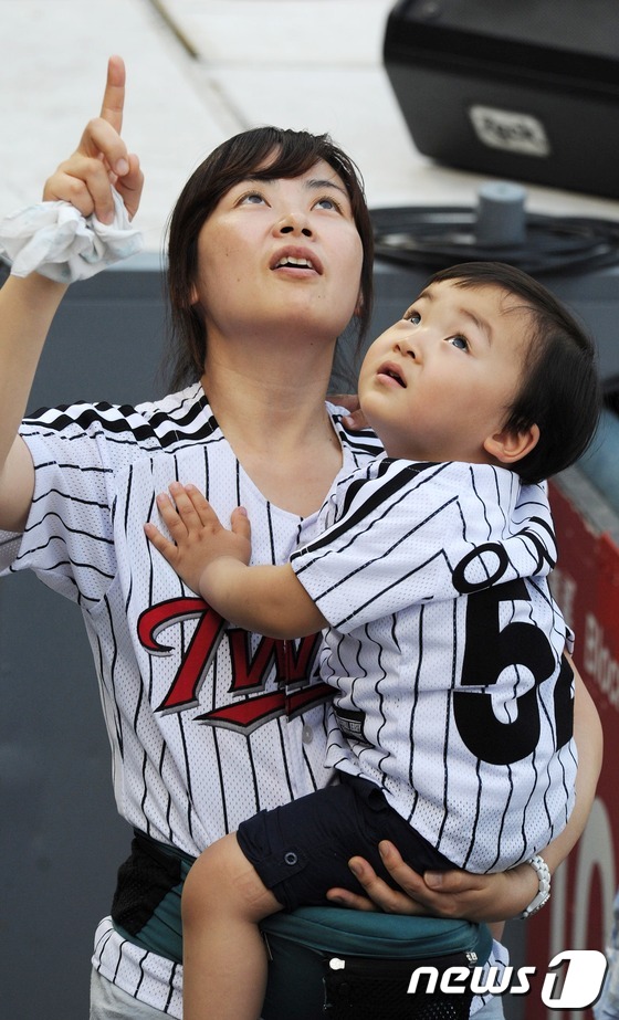 (서울=뉴스1) 박지혜 기자 = 25일 오후 서울 잠실야구장에서 열린 LG와 SK의 경기를 찾은 어린이가 엄마와 함께 날아가는 공을 지켜보고 있다. 이날 서울 낮 최고기온이 31도 …