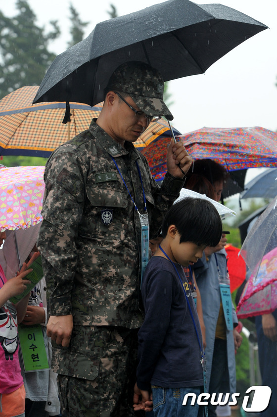 (서울=뉴스1) 안은나 기자 = 27일 서울 동작구 국립서울현충원에서 소외계층 사랑 나눔 활동 어린이들과 국군장병들이 현충탑 앞에서 묵념을 하고 있다. 2013.5.27/뉴스1