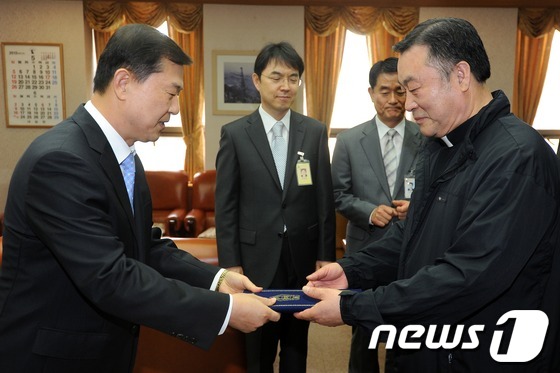 30일 오전 서울 양천구 신정동 서울남부지방법원에서 열린 1일 명예법관 위촉식에서 이성호 법원장(왼쪽)이 김종국 토마스의 집 신부에게 위촉장을 수여하고 있다. 2013.5.30 머 …