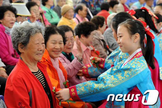 (서울=뉴스1) 안은나 기자 = 어버이날인 8일 서울 송파구 서울놀이마당에서 열린 제41회 어버이날 행사에서 어린이들이 어르신들에게 카네이션을 달아드리고 있다. 2013.5.8/뉴 …