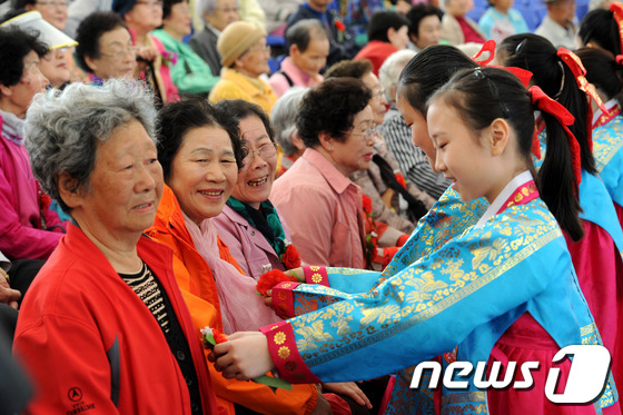 (서울=뉴스1) 안은나 기자 = 어버이날인 8일 서울 송파구 서울놀이마당에서 열린 제41회 어버이날 행사에서 어린이들이 어르신들에게 카네이션을 달아드리고 있다. 2013.5.8/뉴 …