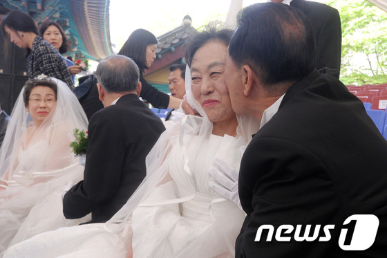 (서울=뉴스1) 안은나 기자 = 어버이날인 8일 서울 송파구 서울놀이마당에서 열린 제41회 어버이날 행사 리마인드 웨딩 리허설에서 한 어르신 부부가 볼에 키스를 하고 있다. 리마인 …