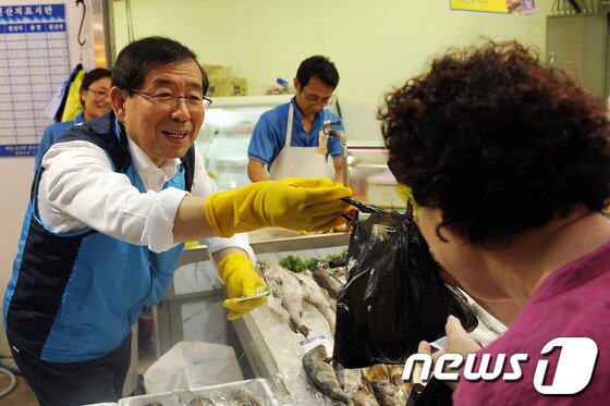 본문 이미지 - 박원순 서울시장이 17일 오후 서울 강북구 수유재래시장을 찾아 한 시민에게 생선을 주고 있다. 이 행사는 '재래시장 현장시장실' 행사의 일환으로 현장의 상인들에게 고충을 직접 듣는다는 취지로 진행됐다. 2013.6.17/뉴스1 © News1   양태훈 인턴기자